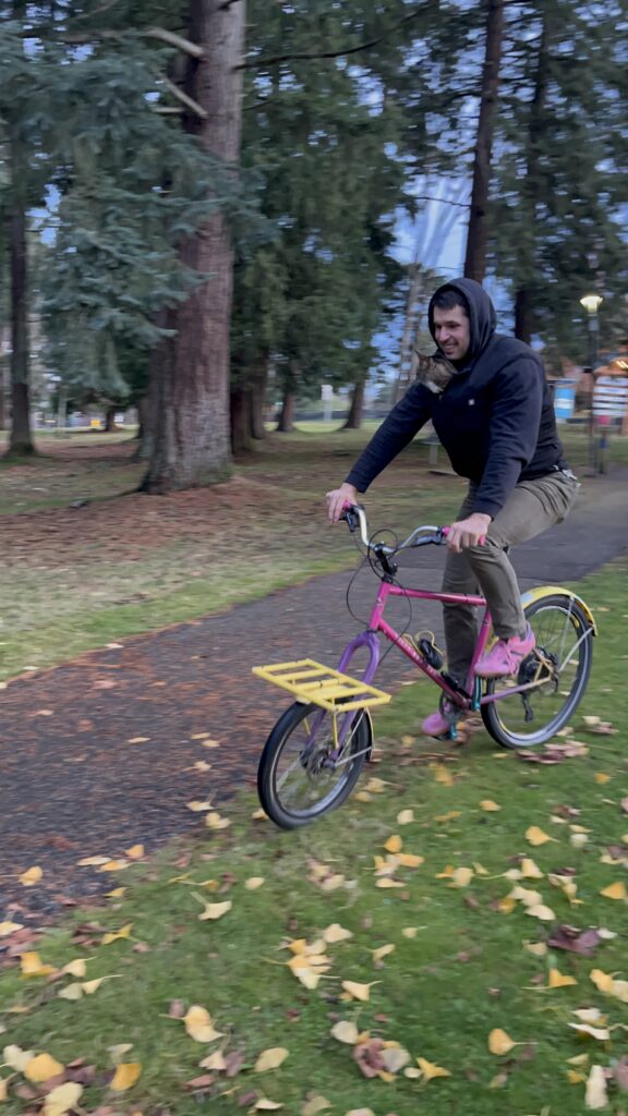 Zero and Random Guy arrive at Bowen Park. Cat on a bike!