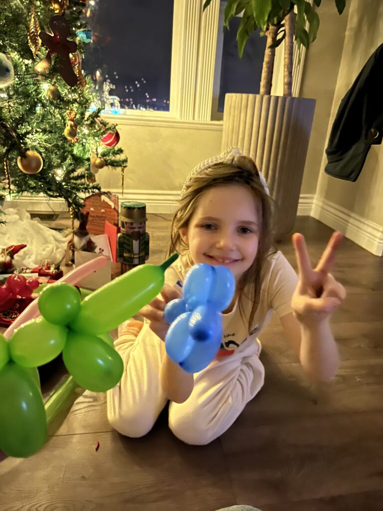 girl holds balloon animal